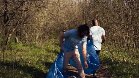 Diverse-activists-cleaning-up-rubbish-in-a-garbage-disposal-bag