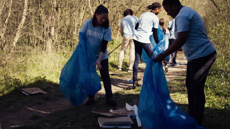 Group-of-diverse-volunteers-collecting-rubbish-from-the-woods-and-recycling