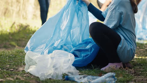 Tired-little-girl-collecting-trash-and-plastic-bottles-from-the-forest