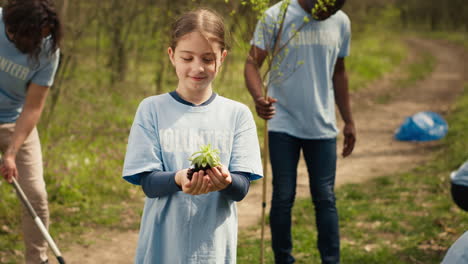Cute-child-activist-presenting-a-small-seedling-tree-in-her-hands