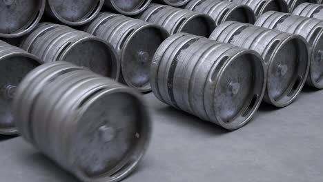Multiple-metal-beer-kegs-rolled-on-the-ground-sequential.-A-camera-moves-back-in-an-endless,-seamless-loop.-Soft-light-illuminates-surfaces-of-cold,-steel,-worn-barrels.-Warehouse-storage-work.