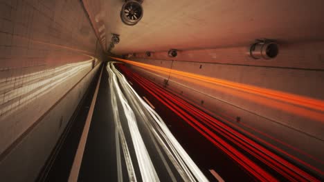 Time-stop-showing-colorful-light-trails-left-by-multiple-fast-cars-in-the-underground-tunnel-covered-with-white-glossy-tiles.-Night-slow-shutter-speed-illustration.-Time-freeze-and-camera-pitch.