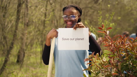 Portrait-of-african-american-activist-holding-poster-with-save-our-planet-message