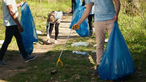 Junge-Freiwillige-Reinigen-Den-Müll-Mit-Einer-Langen-Klaue,-Um-Den-Müll-Aufzufangen