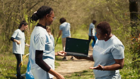 African-american-women-use-laptop-with-greenscreen-during-litter-cleanup