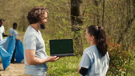 Team-Von-Klima--Und-Naturaktivisten-Nutzt-Laptop-Mit-Greenscreen-In-Der-Nähe-Eines-Waldes