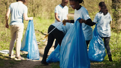 Afroamerikanisches-Mädchen,-Das-Müll-Mit-Einer-Langen-Klaue-Und-Müllsäcken-Aufhebt