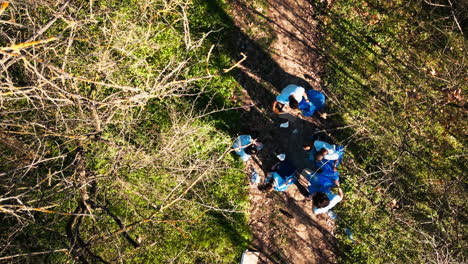 Drone-shot-of-activists-team-cleaning-and-recycling-garbage-in-a-forest