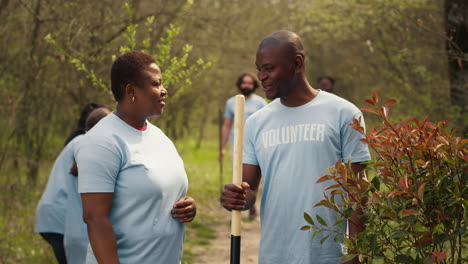 Portrait-of-couple-volunteering-to-plant-trees-and-collect-trash-from-the-woods