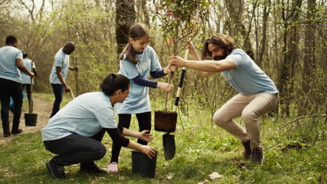 Team-of-volunteers-planting-trees-around-forest-area-for-nature-preservation