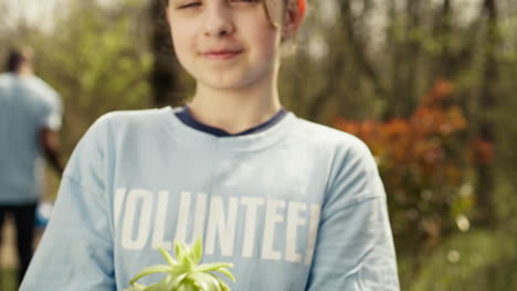 Small-child-holding-soil-with-a-green-sprout-in-her-hands