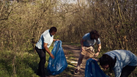 Diverse-volunteers-collecting-garbage-and-junk-from-the-forest-area