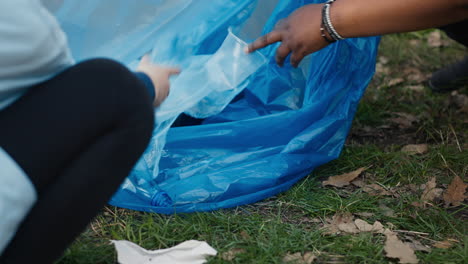 Diverse-volunteers-collecting-trash-and-storing-in-the-garbage-bag