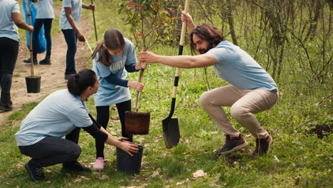 Team-of-volunteers-planting-trees-around-forest-area-for-nature-preservation