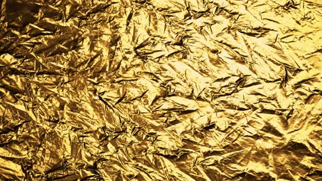 Crumpled,-golden-foil-shining-in-the-soft-spotlight.-Interesting,-endless,-seamless,-abstract-pattern-of-precious-glossy-metal-looking-luxurious-and-expensive.-Perfect-background-graphic.