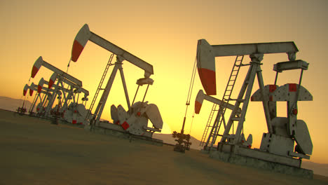 Oil-pump-jacks-pumping-oil-from-the-drilling-to-the-pipeline.-Crude-oil-is-turned-into-gasoline-and-used-as-a-source-of-energy-and-power.-Extracting-machinery-at-the-sunsetting-sky-background.