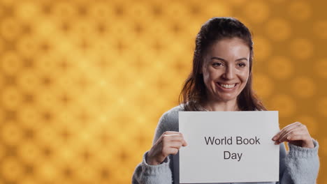 Smiling-book-club-member-holding-placard-with-world-book-day-message