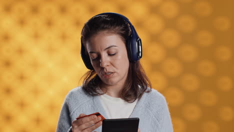 Woman-reading-ebook,-listening-music,-purchasing-books,-studio-background