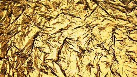 Crumpled,-golden-foil-shining-in-the-soft-spotlight.-Interesting,-endless,-seamless,-abstract-pattern-of-precious-glossy-metal-looking-luxurious-and-expensive.-Perfect-background-graphic.