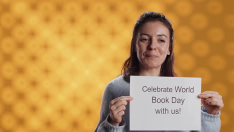 Portrait-of-happy-woman-holding-placard-with-world-book-day-message