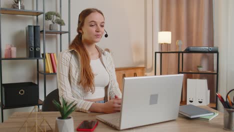 Woman-with-headset-using-laptop,-talking,-working-customer-support-service-operator-at-home-office
