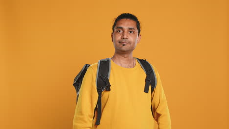 Portrait-of-confident-man-with-thermal-backpack-crossing-arms,-studio-background