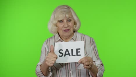 Grandmother-showing-Sale-word-inscription-note,-satisfied-with-low-prices,-shopping-on-Black-Friday