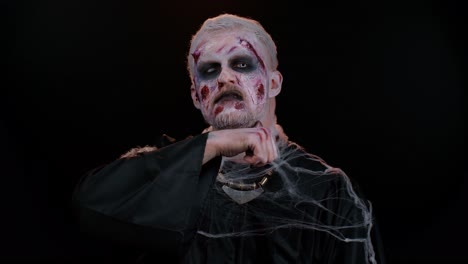 Unheimlicher-Mann-Halloween-Zombie-Versucht-Zu-Erschrecken-Zeigt-Tötungsgeste,-Fährt-Mit-Dem-Finger-An-Seinem-Hals-Entlang