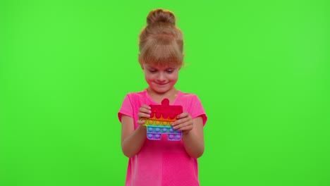 Child-girl-playing-squishy-silicone-bubbles-sensory-toy-simple-dimple-pop-it-game,-green-chroma-key