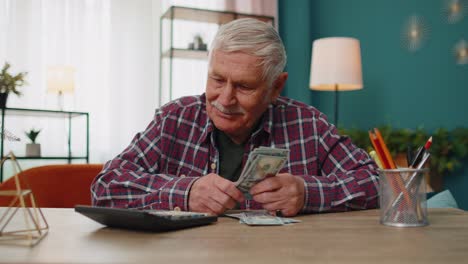 Glücklicher-Großvater-Mann-Zählt-Und-Berechnet-Bargeld,-Dollar,-Plant-Ausgaben,-Finanzbudget