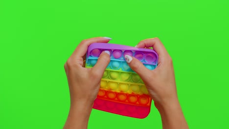 Close-up-of-girl-hands-playing-squeezing-anti-stress-toys-simple-dimple-game-isolated-on-chroma-key