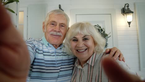 Älteres-Kaukasisches-Paar-Nutzt-Mobiltelefon-Für-Videoanrufe-Und-Macht-Selfie-Auf-Der-Veranda-Zu-Hause
