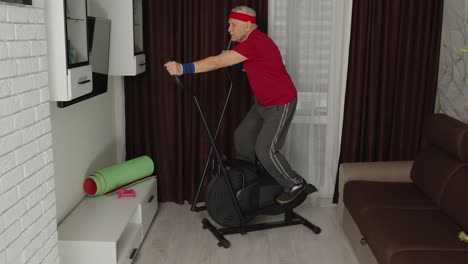 Active-healthy-senior-old-mature-man-in-sportswear-using-orbitrek,-training-cardio-workout-at-home