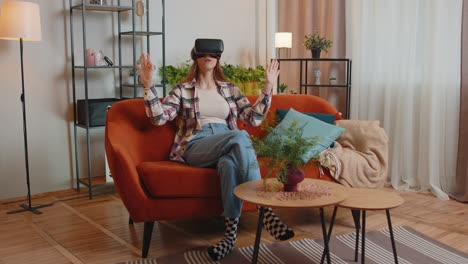 Young-girl-use-virtual-reality-headset-glasses-at-home-play-3D-video-game-making-gestures-with-hands