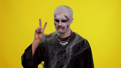 Halloween-zombie-man-bloody-make-up-showing-victory-sign,-hoping-for-success-and-win-peace-gesture