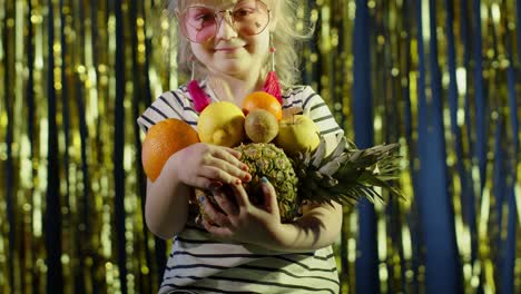 Trendy-girl-in-pink-sunglasses-posing-looking-at-camera-with-bunch-of-fruits-in-hands-in-night-club
