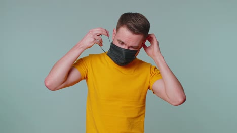 Sad-unhappy-man-putting-on-face-medical-mask-prevent-respiratory-Coronavirus-infection-flu-disease