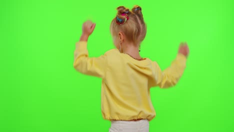 Cheerful-funny-little-teen-girl-kid-dancing-at-camera-filming-video-using-phone-on-chroma-key-wall