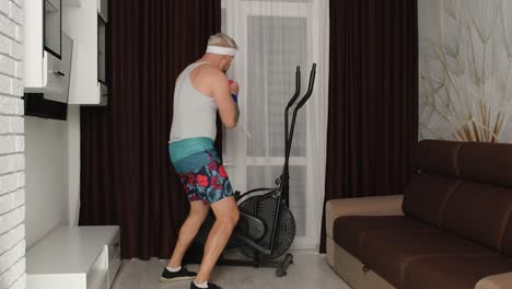 Sportsman-stylish-fat-guy-in-funny-clothes-making-boxing-exercises-with-dumbbells-in-place-at-home
