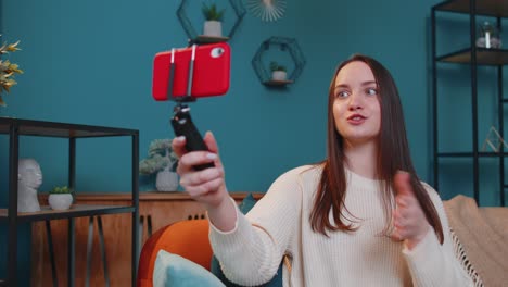 Girl-blogger-influencer-taking-selfie-on-smartphone,-make-virtual-social-media-video-online-at-home