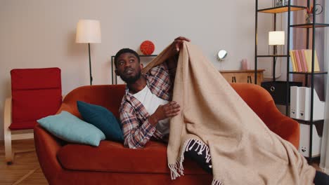 Terrified-scared-african-american-young-man-wakes-up-from-stress-nightmare-in-bedroom-at-home-sofa