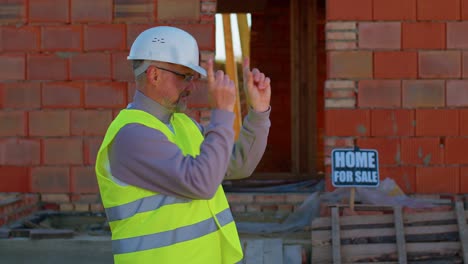 Engineer-architect-looking-approvingly-at-camera-showing-thumbs-up,-recommending-buying-a-house