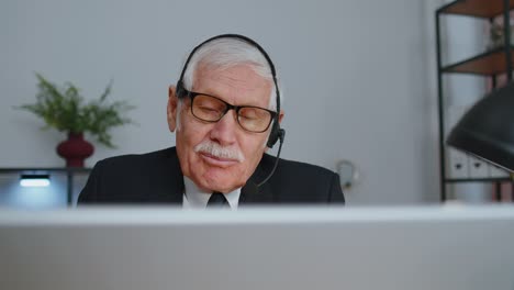 Senior-old-businessman-wearing-headset-working-in-office,-call-center,-conference,-support-agent