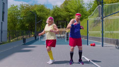 Funny-elderly-man-woman-athletes-working-out-in-basketball-court-doing-training-dancing-exercising
