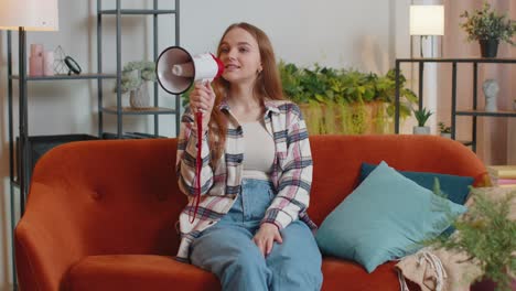 Young-woman-shout-in-megaphone-loudspeaker-announces-discounts-sale-of-real-estate-at-home-on-sofa