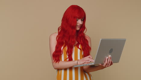 Redhead-girl-working-online-on-laptop-showing-thumb-up-positive-good-feedback,-like,-lottery-win
