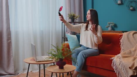 Girl-blogger-influencer-taking-selfie-on-smartphone,-make-virtual-social-media-video-online-at-home