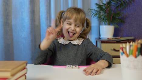 Kleines-Mädchen,-Das-Auf-Eine-Webkamera-Blickt-Und-Einen-Videoanruf-Macht,-Zu-Hause-Unterricht-Nimmt-Und-Lächelt-Und-Die-Zunge-Zeigt