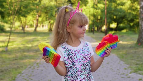 Children-girl-kid-holding-pop-it-sensory-toy,-trendy-fidgeting-anti-stress-silicone-bubbles-game