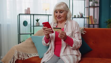 Ältere-Frau-Hält-Kreditkarte,-Gibt-Deren-Nummer-Ins-Mobiltelefon-Ein-Und-Kauft-Online-Waren